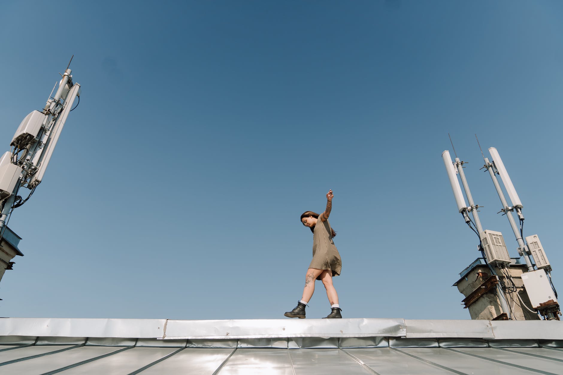 man in brown shorts jumping on white concrete building